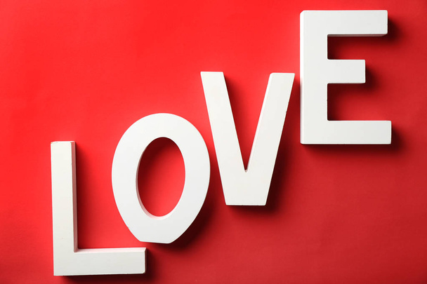 Word LOVE made of white letters on color background - Фото, изображение