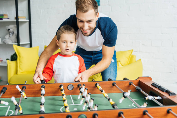 father and son playing table football together at home - Fotó, kép