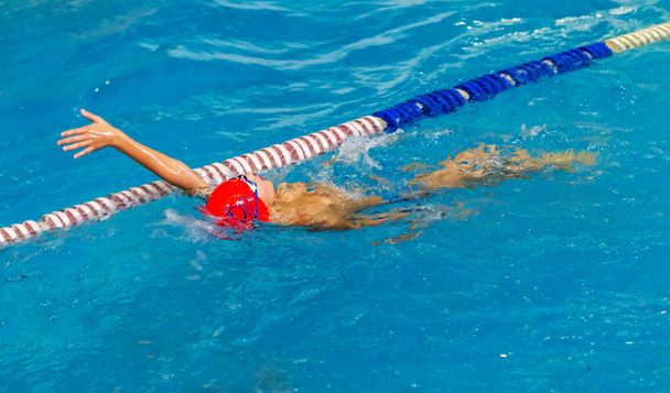 ODESSA, UKRAINE - CIRKA 2016: Crianças, atletas, nadadores nadam ao longo de pistas na piscina desportiva para nadar. Esportes nadando na piscina. Verão esporte olímpico, estilo de vida saudável, esporte infantil
 - Foto, Imagem