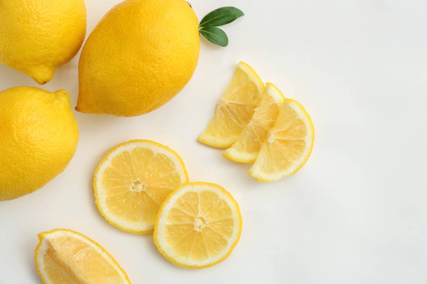 Flat lay composition with ripe juicy lemons on white background - Fotó, kép