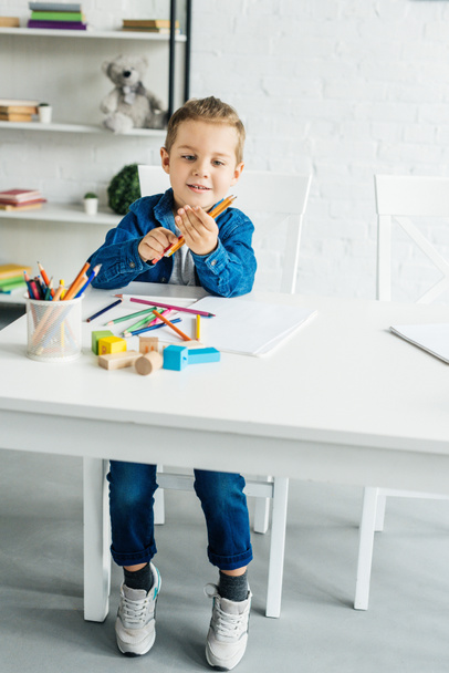 happy little child drawing with color pencils at home - Fotó, kép