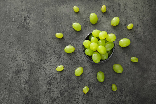 Bowl with ripe juicy grapes on grey table - Photo, Image