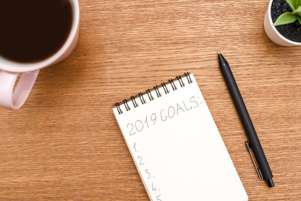 Top view 2019 goals list with notebook, cup of coffee on wooden - Foto, imagen