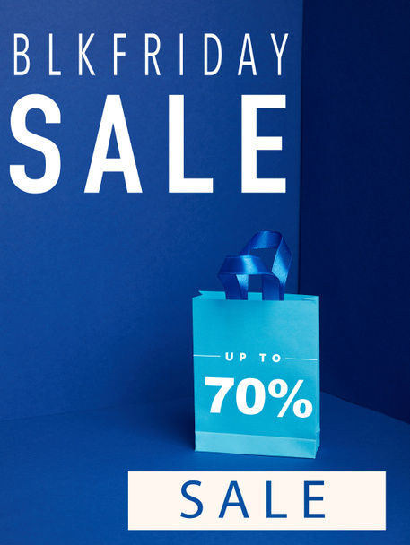 close up view of paper shopping bag on blue with blkfriday and 70 percents sale - Photo, Image