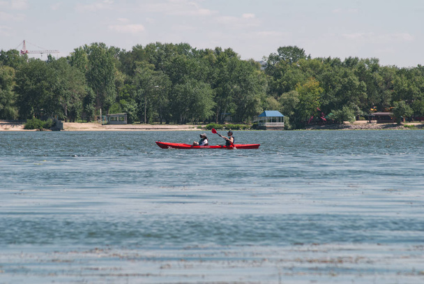 Pair in a red kayak, kayaking on the Dnieper, the concept of rowing, - Photo, Image