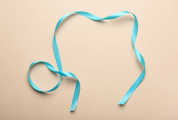 Curled blue ribbon on color background - Photo, Image