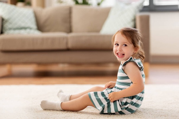 happy baby girl sitting on floor at home - Foto, Imagen