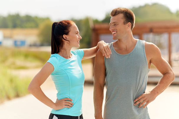 happy couple in sports clothes outdoors - Photo, Image
