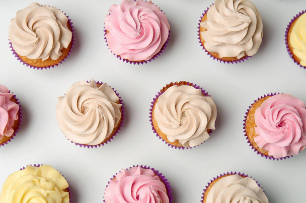 Deliciosos cupcakes no fundo branco, flat lay
 - Foto, Imagem