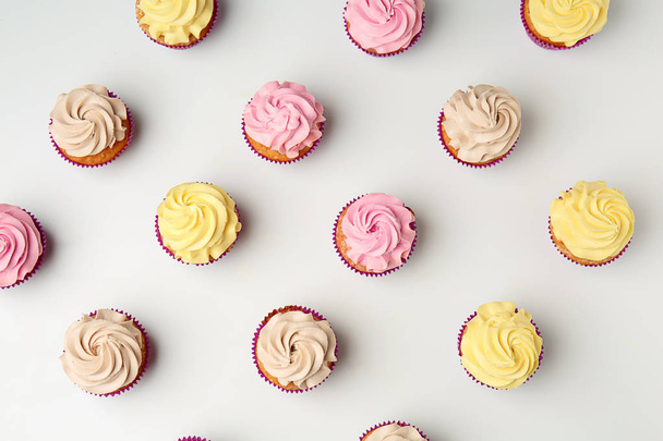 Delicious cupcakes on white background, flat lay - Photo, Image