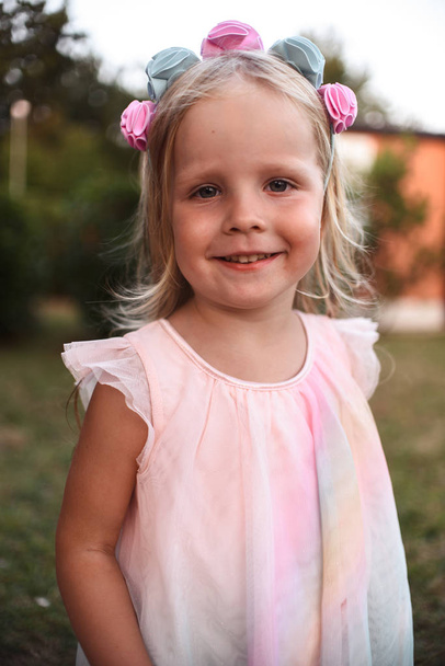 portrait of cute little blonde girl in pink dress posing outdoor at summer day - Zdjęcie, obraz