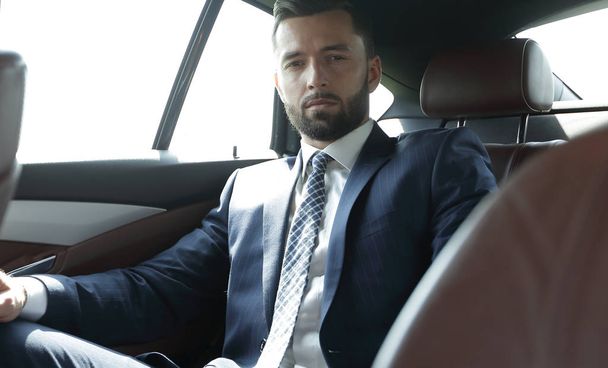Successful businessman sitting in the back seat of a car - Fotó, kép