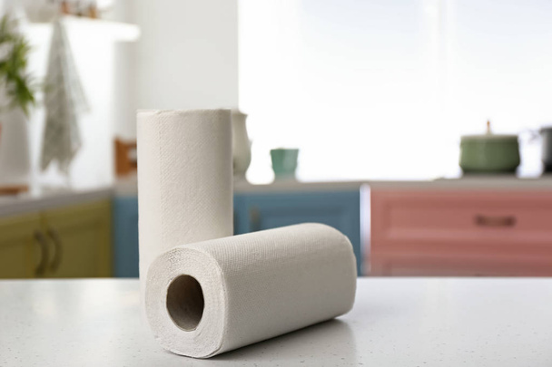 Rollen van papieren handdoeken op de keukentafel - Foto, afbeelding