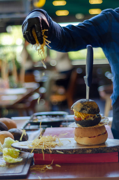 Připraven sloužit hamburger, rychlé občerstvení. Je to na dřevěný stůl. Rozmazané pozadí. - Fotografie, Obrázek