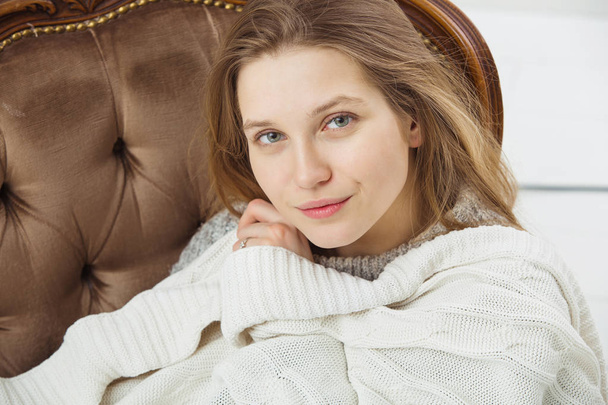 Mulher sentada em poltrona vintage com cobertor
 - Foto, Imagem