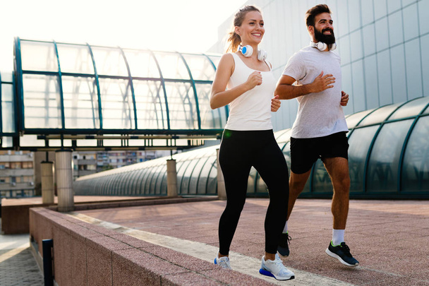 Young fitness couple running together in urban area - Foto, immagini