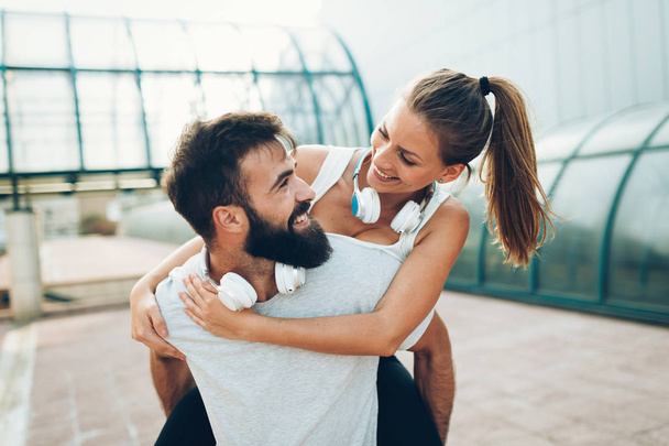 Portrait of young attractive happy fitness couple together outside - Φωτογραφία, εικόνα