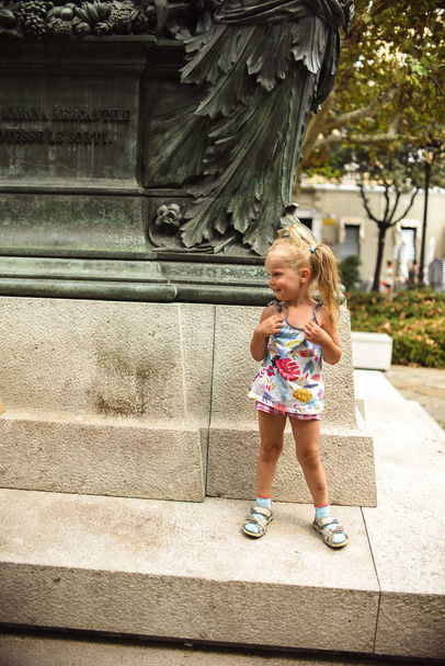 Doce menina brincando perto do monumento
 - Foto, Imagem