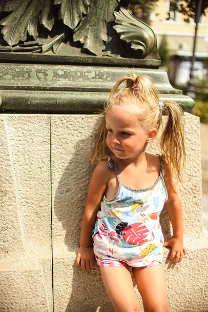 Sweet little baby girl playing near monument - Foto, Imagem