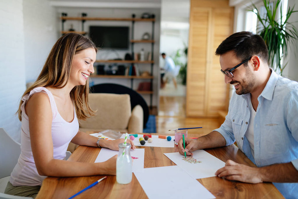 Happy young couple having fun drawing at home - Fotoğraf, Görsel
