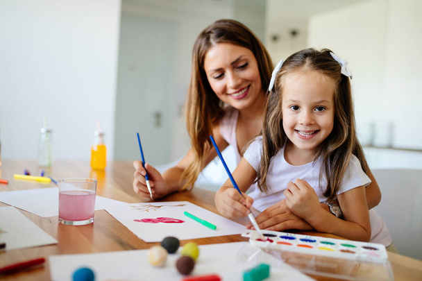 Little girl painting with her mother together at home - Fotoğraf, Görsel