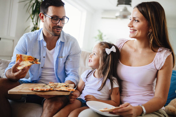 Happy smiling family sharing pizza together at home - Φωτογραφία, εικόνα
