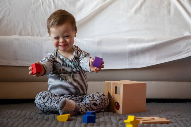 Portret van schattige jongen met syndroom van Down spelen in huis - Foto, afbeelding