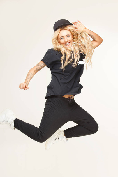 jump stylish blond woman in fashionable swag look on white isolated. - Фото, изображение