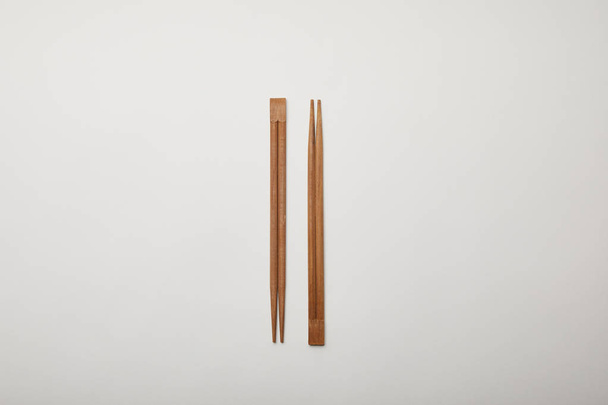 top view of arranged chopsticks on white surface, minimalistic concept  - Fotó, kép