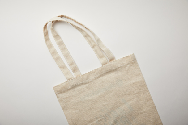 elevated view of cotton bag on white surface, minimalistic concept  - 写真・画像