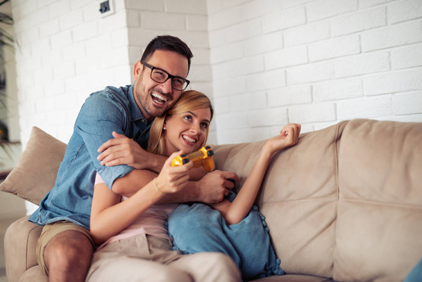 Cheerful couple playing video games at home - Φωτογραφία, εικόνα