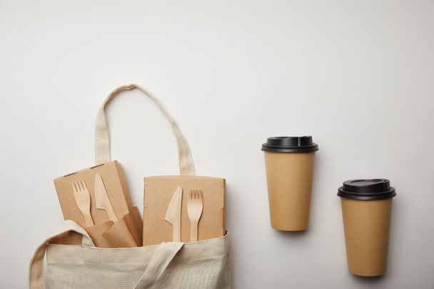 view from above of cotton bag with food boxes and two disposable coffee cups on white surface - Photo, Image
