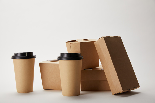 disposable coffee cups and cardboard food boxes on white - Fotoğraf, Görsel