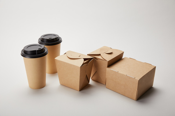 close up view of paper coffee cups and cardboard food boxes on white - Photo, Image