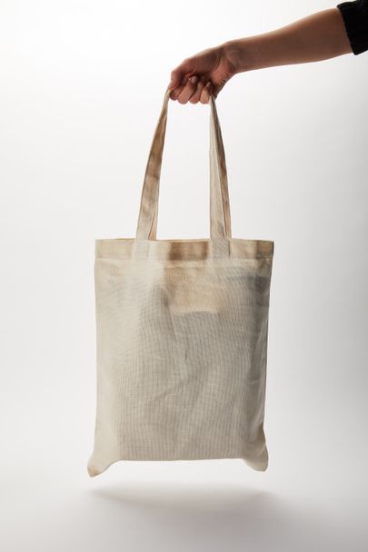 cropped image of woman holding cotton bag with food delivery on white - Photo, Image