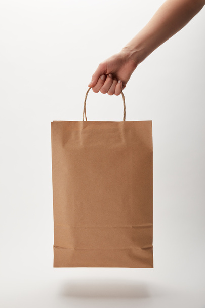 cropped image of woman holding paper bag with food delivery on white - Foto, immagini