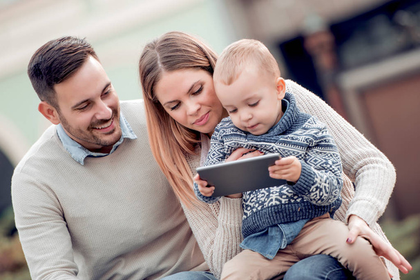  famille heureuse regardant tablette ensemble en ville en plein jour
 - Photo, image