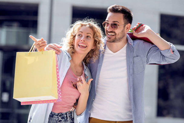 Cheerful couple with shopping bags in city - Photo, Image