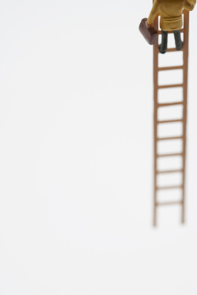 Businessman Figurine Climbing On Ladder - Foto, Bild