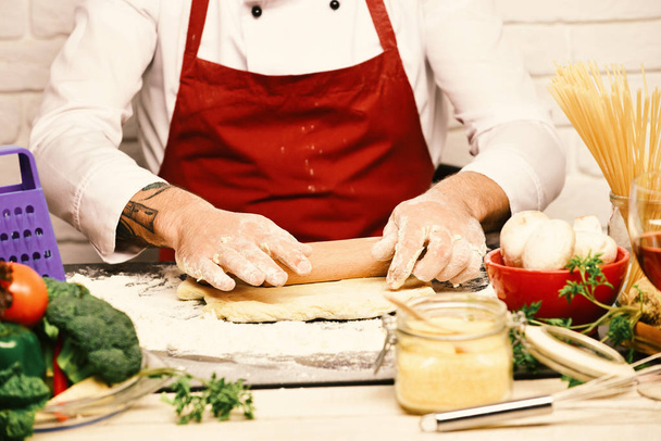 Cooking process concept. Chef makes dough. Cook in burgundy uniform - Fotó, kép