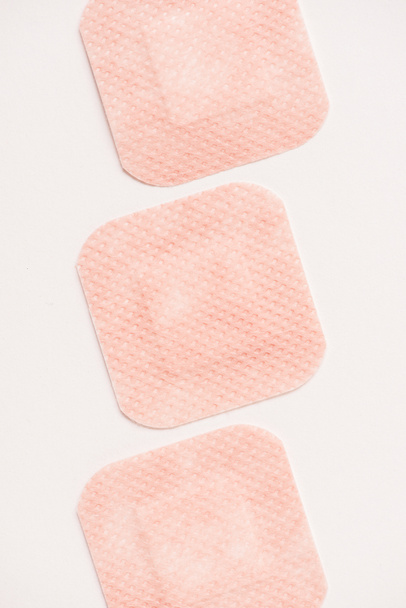 top view of row of adhesive bandages on white surface - Foto, afbeelding