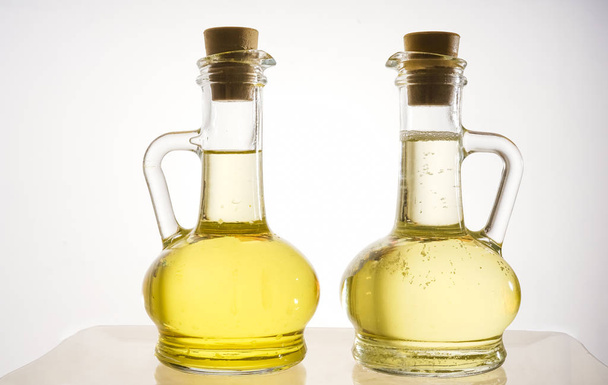 oil in two jars, isolated on white background.  - Foto, imagen