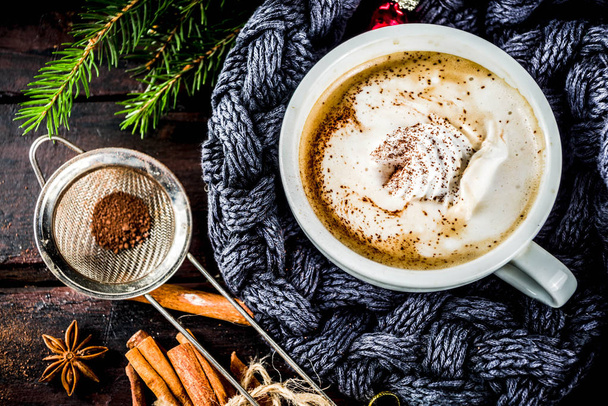 Pittige cappuccino koffie met voor koude winter en herfst dag. Xmas ochtend concept. Klassieke houten achtergrond met kerstboom en decorations, kopie ruimte bovenaanzicht - Foto, afbeelding