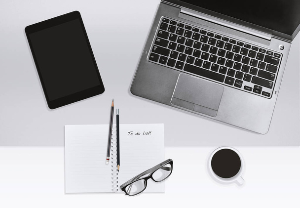 Modern office workplace, Home office business or education concept. Top view of laptop, open notebook with empty tasks, to do list with coffee cup and eyeglasses on light background. Mock up. - Photo, image