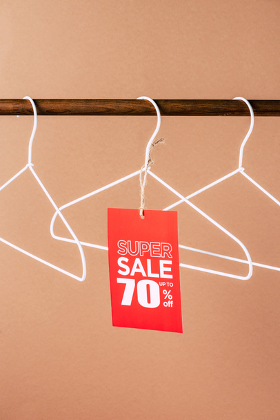 hangers with red super sale tag - 70 percents discount on beige - Foto, afbeelding