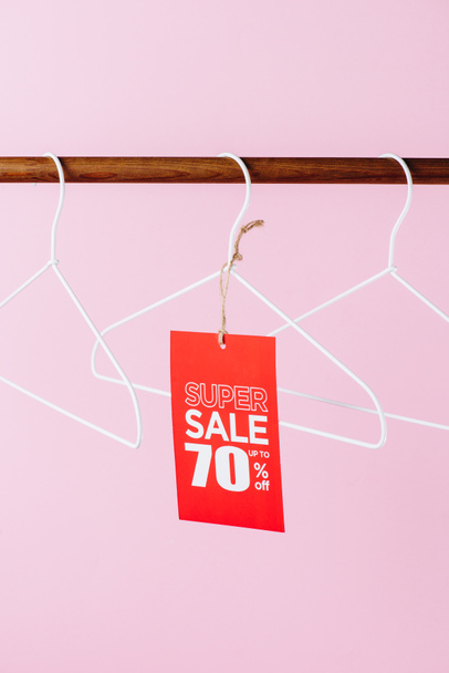Kleiderbügel mit rotem Super Sale Tag - siebzig Prozent Rabatt auf rosa - Foto, Bild