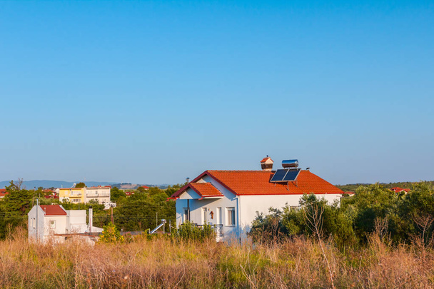A megújuló napenergia felhasználására szolgáló vízpaneleket háztetőre, napenergiával működő melegvíz-rendszerbe helyezik. Modern energiatakarékossági technológia - Fotó, kép