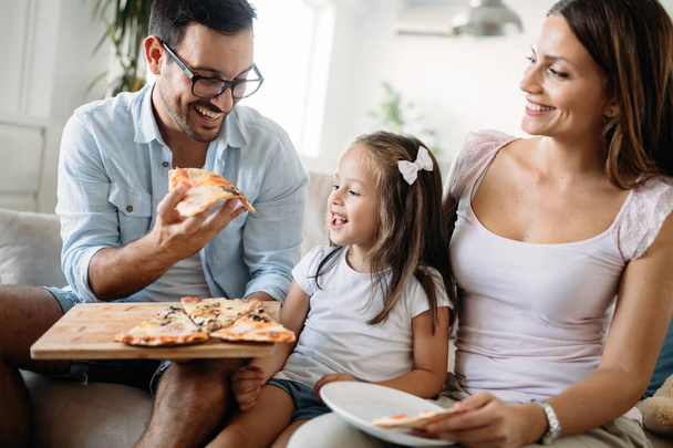 Portrait of happy family sharing pizza together at home - Fotografie, Obrázek