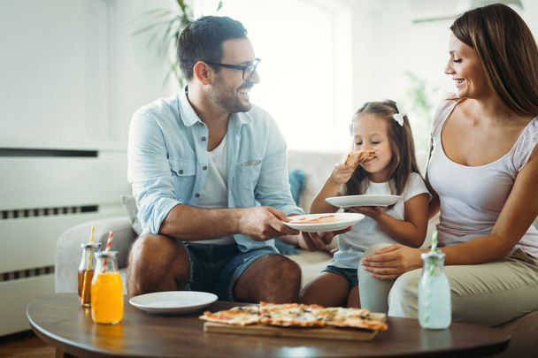 Portrait of happy family sharing pizza together at home - Φωτογραφία, εικόνα