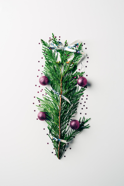top view of green pine branch decorated with christmas toys and ribbon as christmas tree on white backdrop - Photo, Image